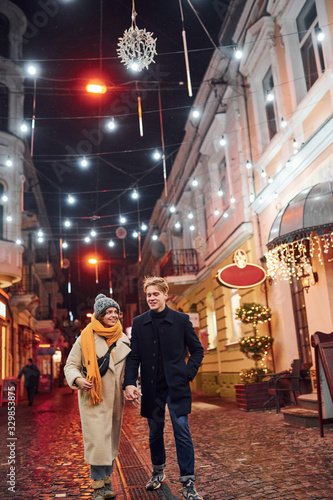 Couple have a walk together on the christmas decorated street