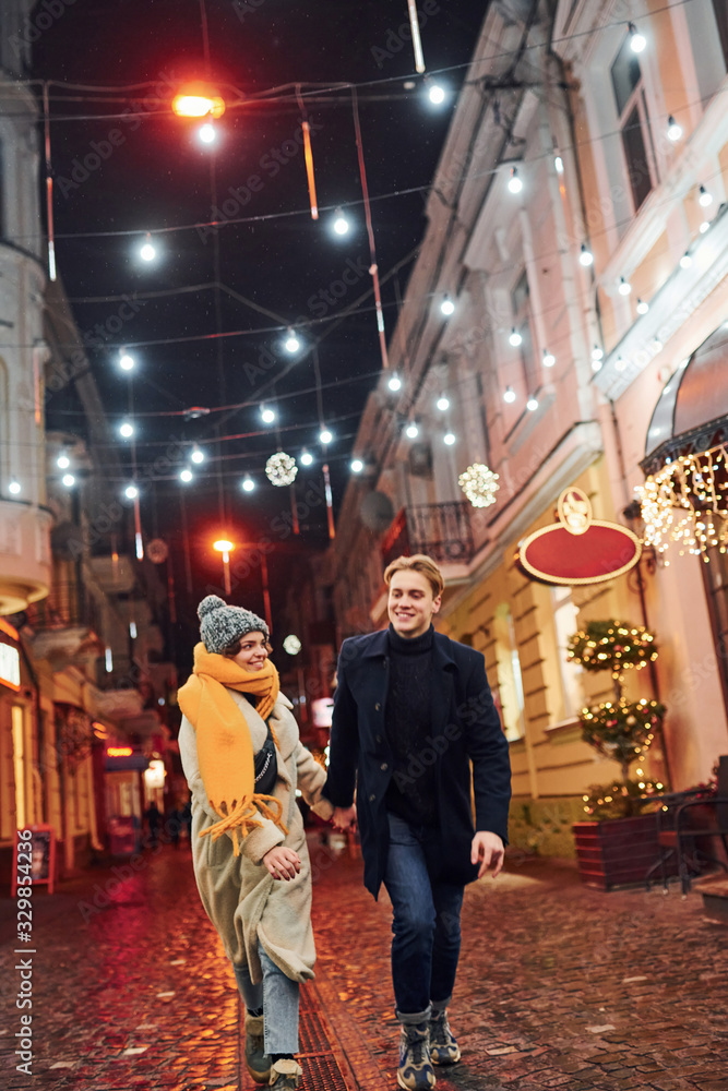 Couple have a walk together on the christmas decorated street Couple have a walk together on the christmas decorated street