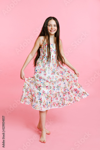 Portrait of adorable smiling little girl child dancing in dress isolated