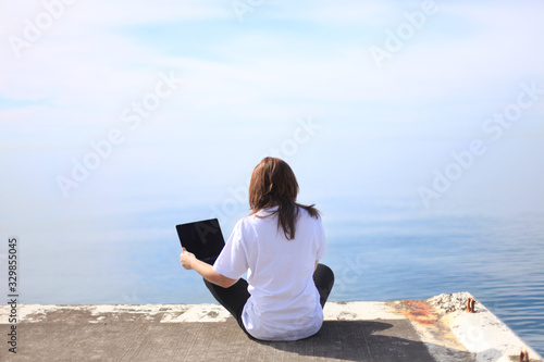 young woman with tablet computer on the beach