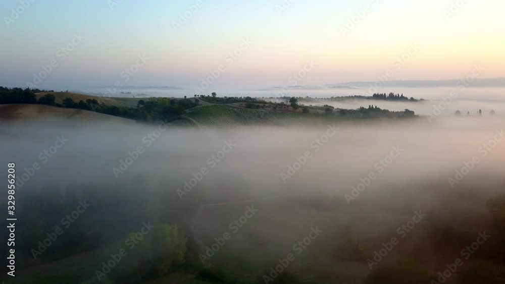 Farm fields in Toscany Italy on a foggy morning during sunrise, Aerial slow lowering shot Farm fields in Toscany Italy on a foggy morning during sunrise, Aerial slow lowering shot