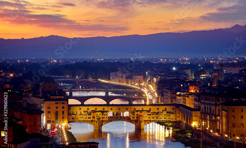 Evening sunset over Florence with Ponte Vecchio bridge on Arno river and tower in Italy.