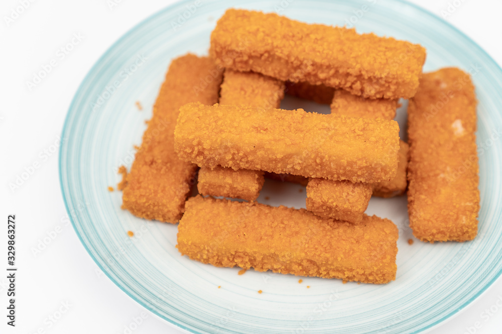 Fried fish sticks on the plate above white background Fried fish sticks on the plate above white background