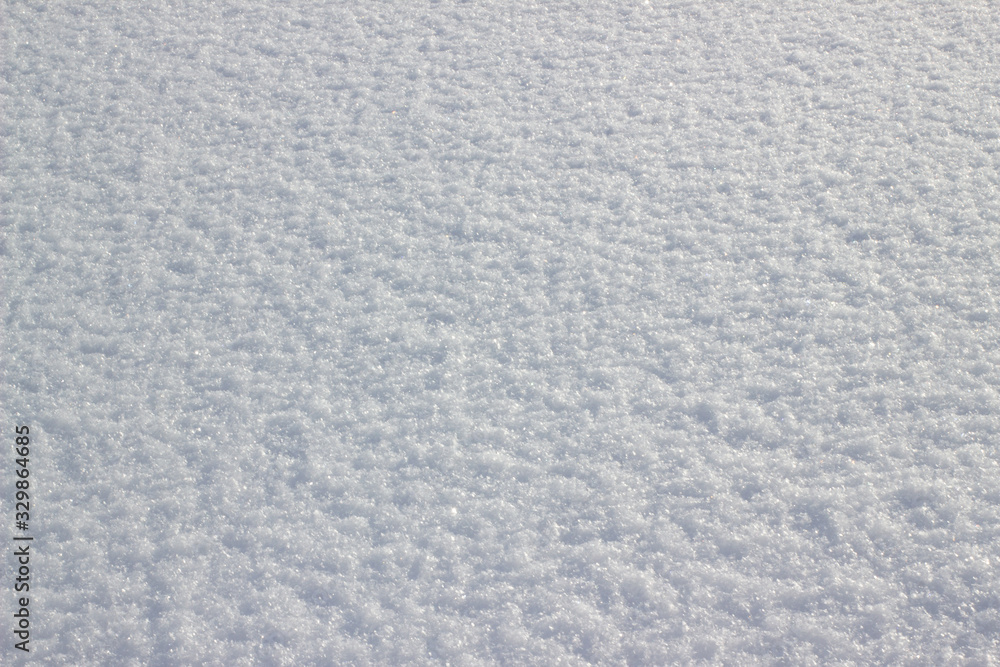 Background of fresh snow. White snow texture on a sunny winter day. Soft focus