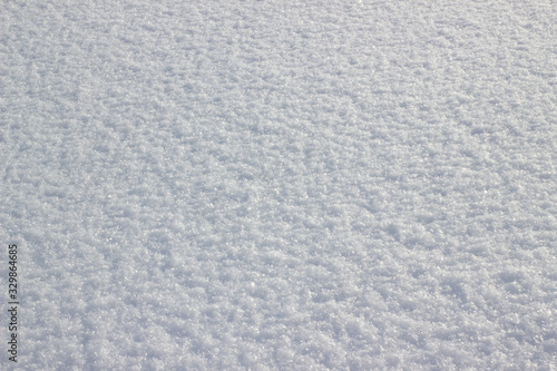 Background of fresh snow. White snow texture on a sunny winter day. Soft focus