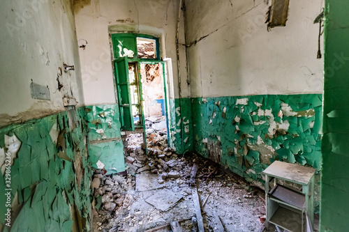 Ruined corridor with piles of garbage in abandoned asylum © Ievgen Skrypko