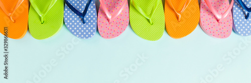 Fotografi a lot of flip flop colored sandals, summer vacation on colored background, banne