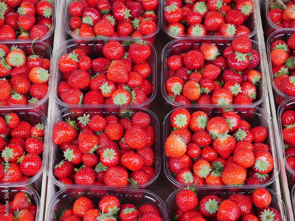 Strawberries in bright red, presented in transparent sales bowls. The sharpness of the image is in the middle Strawberries in bright red, presented in transparent sales bowls. The sharpness of the image is in the middle