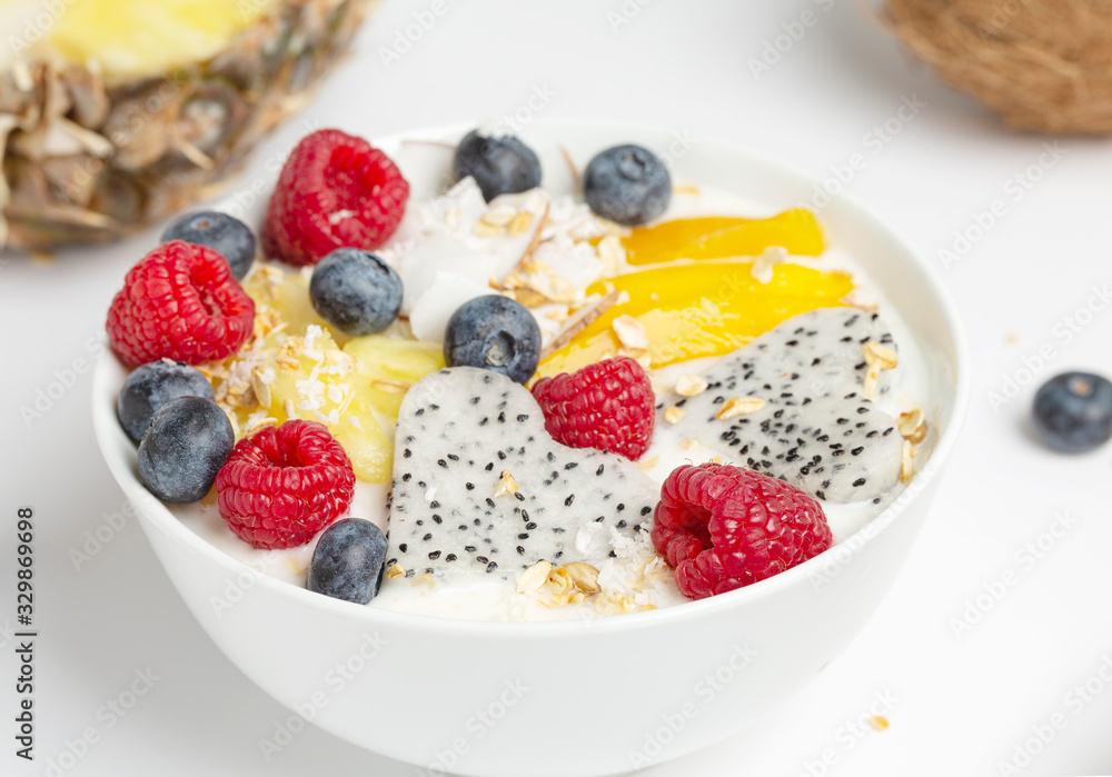Healthy breakfast Smoothie bowl with mango, pineapple, dragon fruit, blueberries, raspberries and coconut. Tasty summer breakfast. Healthy breakfast Smoothie bowl with mango, pineapple, dragon fruit, blueberries, raspberries and coconut. Tasty summer breakfast.