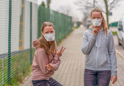 2 Jugendliche Mädchen Menschen mit Atemmaske auf der Straße in Deutschland wegen Coronavirus photo