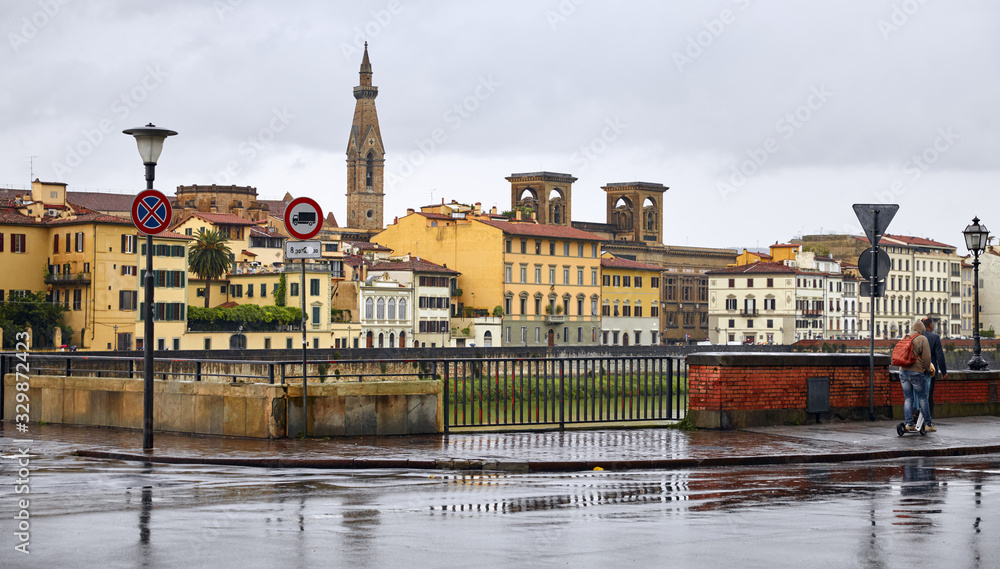 Florence Italy. Embankment river Arno in rainy weather day with view at old house and tower.