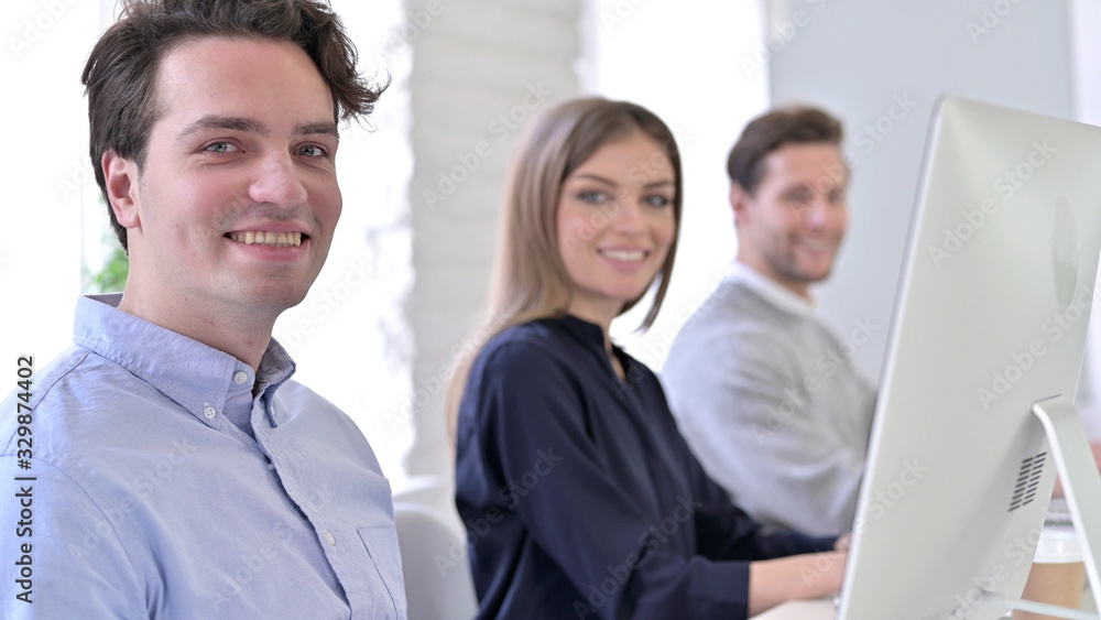 Creative People using Desktop and Smiling at the Camera Creative People using Desktop and Smiling at the Camera