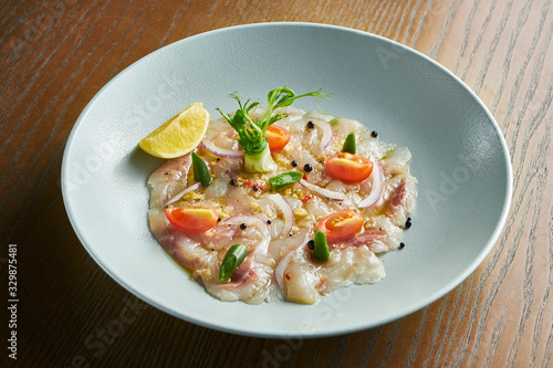 Close up view sea bass ceviche served in white bowl wooden background. Fresh and tasty cebiche. Raw fish. Latin America cuisine. Noise grain on post