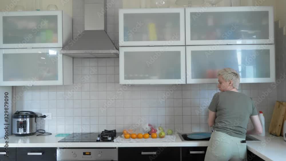 a woman washes vegetables and fruits in the kitchen at home. a woman washes vegetables and fruits in the kitchen at home.