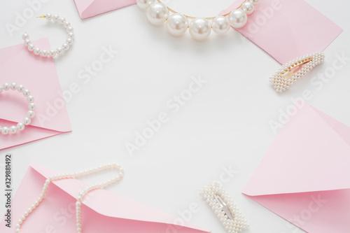 Wedding text background, white, decorated with pink invitation envelopes, top view, with copy space. The concept of a wedding date or a gentle background for the bride.