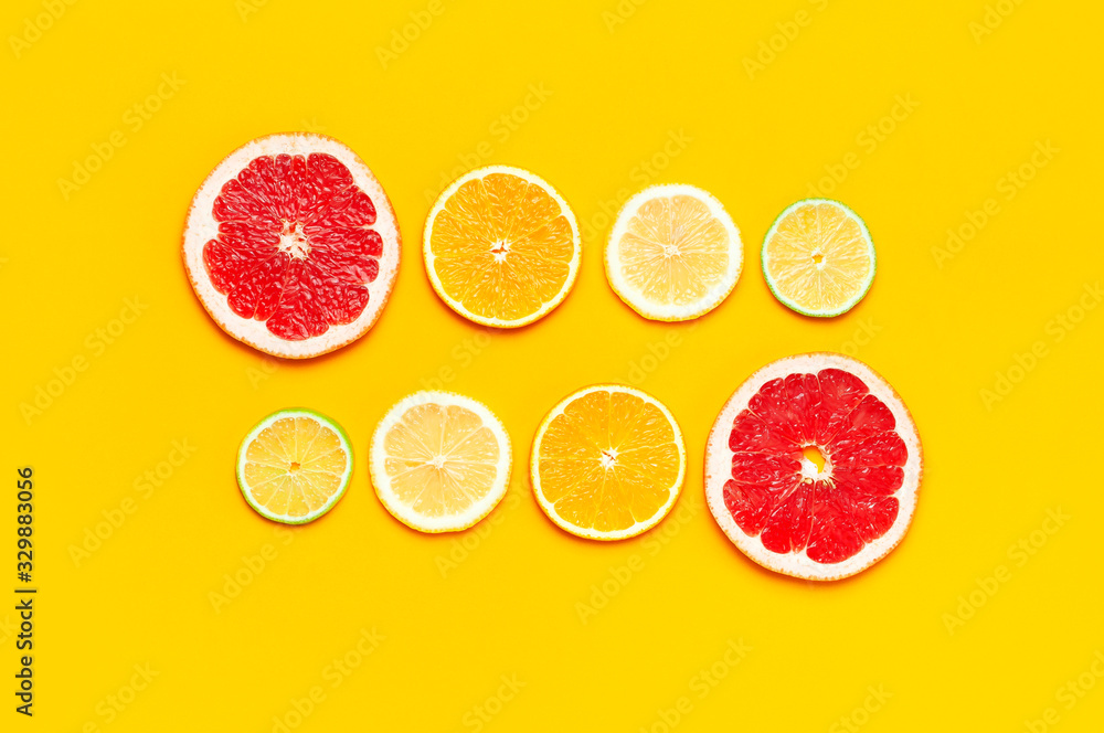 Flat lay composition with slices of fresh lemon orange grapefruit lime on yellow background top view copy space. Citrus Juice Concept, Vitamin C, Fruits. Creative summer background Flat lay composition with slices of fresh lemon orange grapefruit lime on yellow background top view copy space. Citrus Juice Concept, Vitamin C, Fruits. Creative summer background