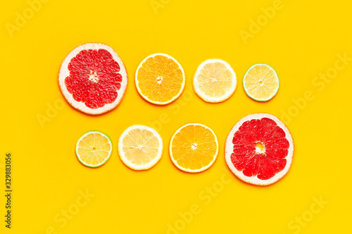 Flat lay composition with slices of fresh lemon orange grapefruit lime on yellow background top view copy space. Citrus Juice Concept  Vitamin C  Fruits. Creative summer background