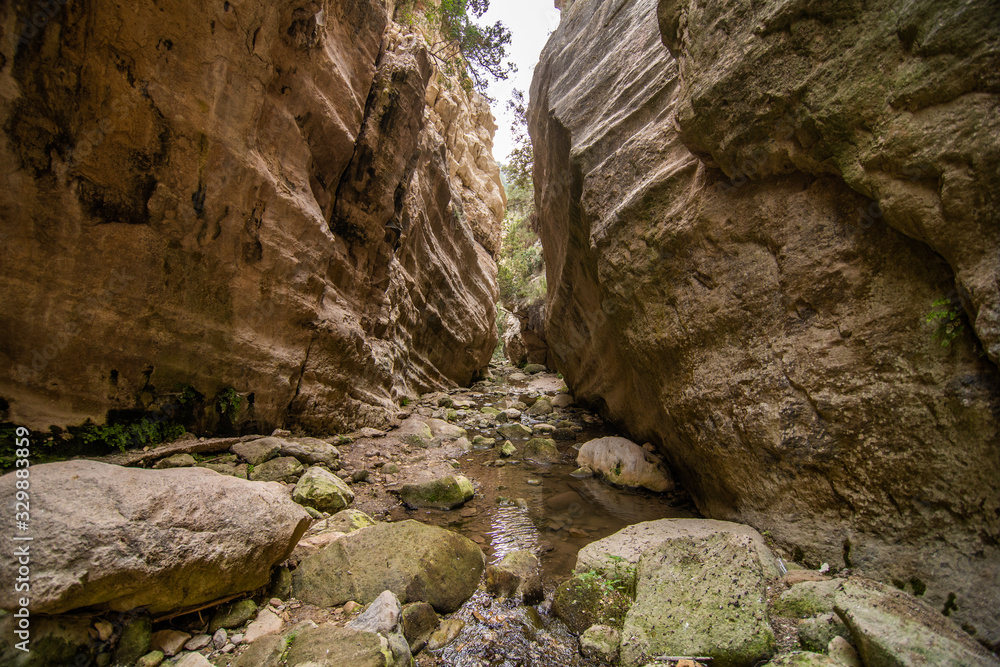 Avakas Gorge in Cyprus. Little river in foreground, sunlit rocks are in background