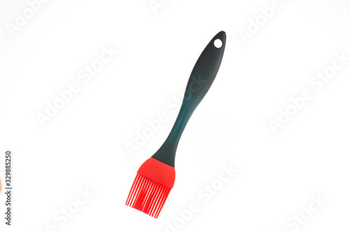 Fotografija Single plastic red silicon kitchen brush close up shot isolated on pure white