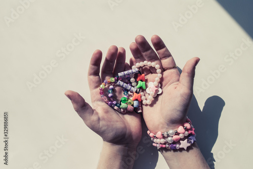 bead bracelets. beads in the hands. decorations. bijouterie. hobbies of girls. rings. background