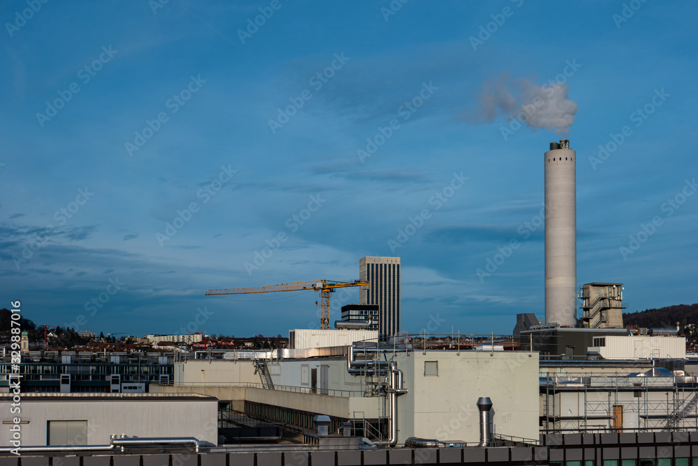 High vantage point view of industrial area of Zurich city Switzerland concrete smoking chimney in the background sunny day