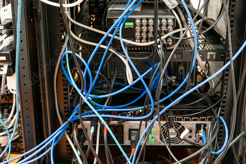 Foto Convoluted mess of power sockets and tangled electrical cables tied together wit
