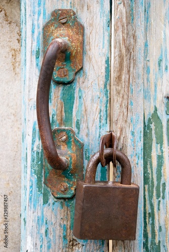Old padlock and doorknob on antique door