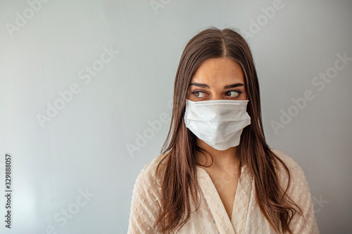 Woman in a medical mask close-up on a gray background. Healthy lifestyle, ill sick disease treatment concept. Mock up copy space. epidemic, dangerous and deadly virus, infection concept