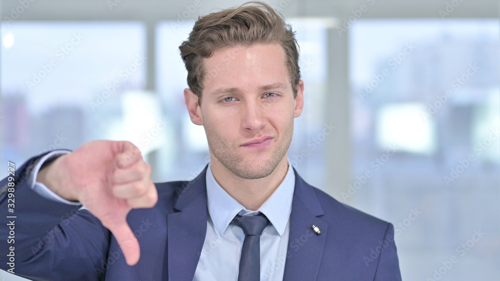 Portrait of Disappointed Young Businessman showing Thumbs Down Portrait of Disappointed Young Businessman showing Thumbs Down