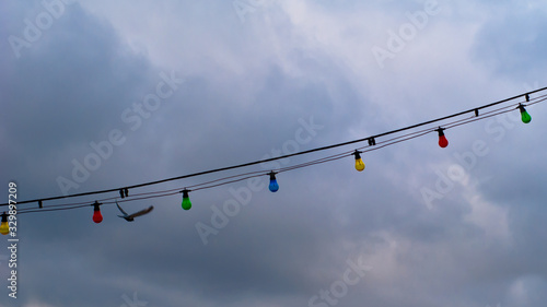 gray background, clouds and electric colored light bulbs