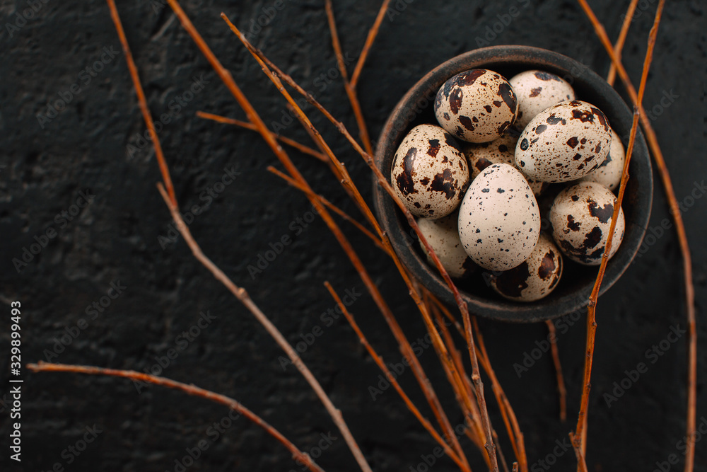 Obraz premium wooden bowl filled with quail eggs on a dark background. Creative food concept.