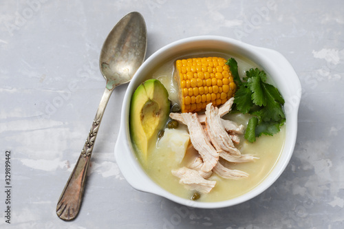 soup potato with corn and chicken in white bowl on ceramic background photo