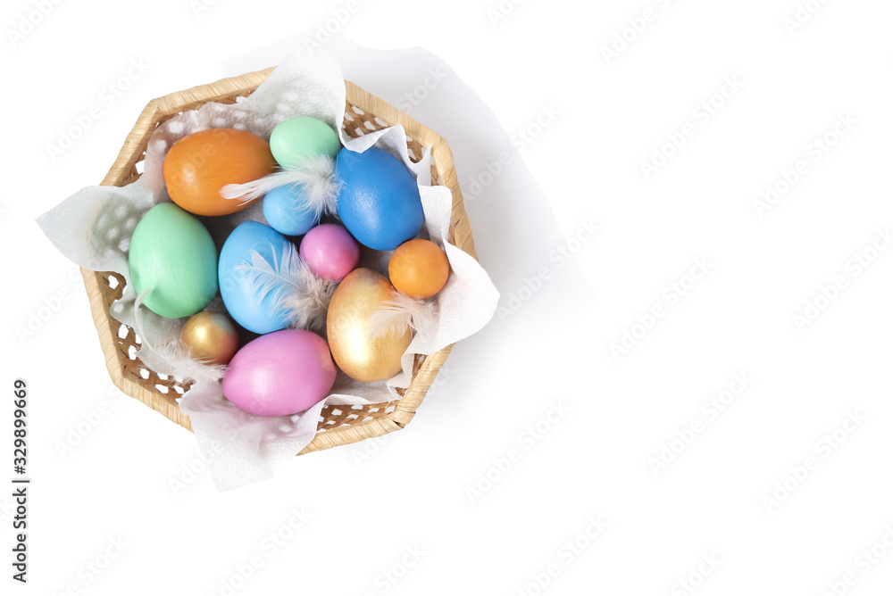 Golden, pink, blue, green, orange eggs in the wicker basket on the white background. Copy space. Place for text and design. Happy Easter. Top view. Flat layout. Golden, pink, blue, green, orange eggs in the wicker basket on the white background. Copy space. Place for text and design. Happy Easter. Top view. Flat layout.
