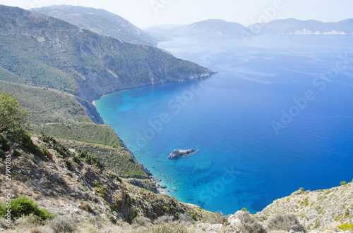 Deep azure Mediterranean sea with misty hills and shoreline of the Greek islands