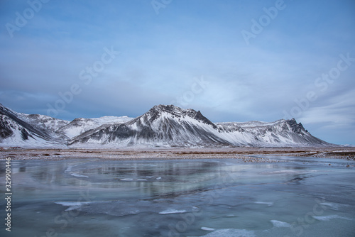Frozen lake with snow covered mountains in Iceland 