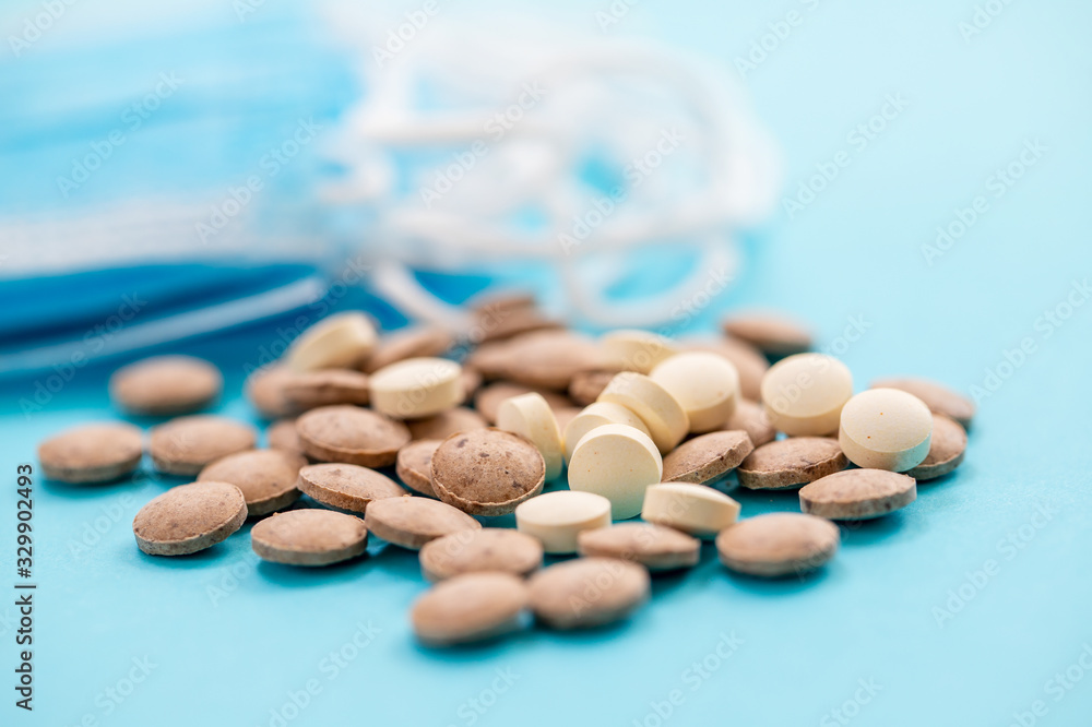medical mask and different pills on blue background medical mask and different pills on blue background