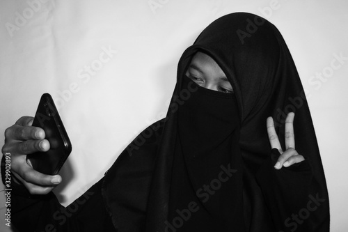 Close up view of Pretty lady woman girl wear hijab jilbab niqab kerudung niqaab scarf cover face and only show visible look of her beauty eyes. Fit for put design life image. Black white grain texture photo