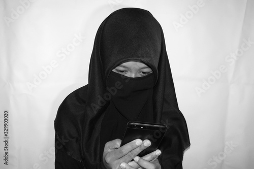 Close up view of Pretty lady woman girl wear hijab jilbab niqab kerudung niqaab scarf cover face and only show visible look of her beauty eyes. Fit for put design life image. Black white grain texture photo