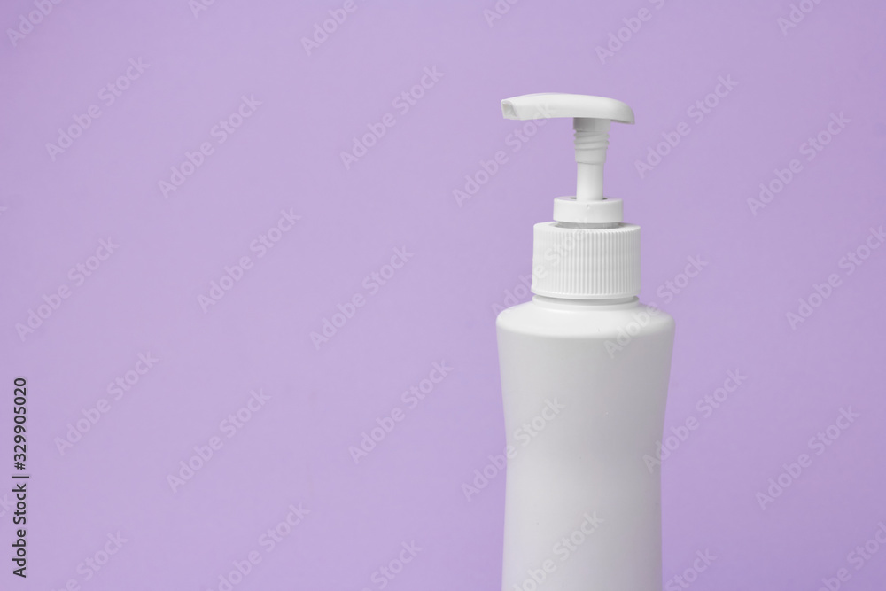 Mock up of white bottle with a dispenser on a purple background. Cosmetics packaging. Copy space for advertisement for cosmetic product. Mock up of white bottle with a dispenser on a purple background. Cosmetics packaging. Copy space for advertisement for cosmetic product.