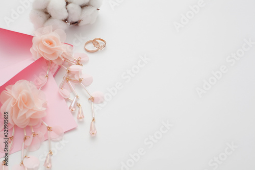 Wedding text background, white, decorated with pink invitation envelopes, top view, with copy space. The concept of a wedding date or a gentle background for the bride.