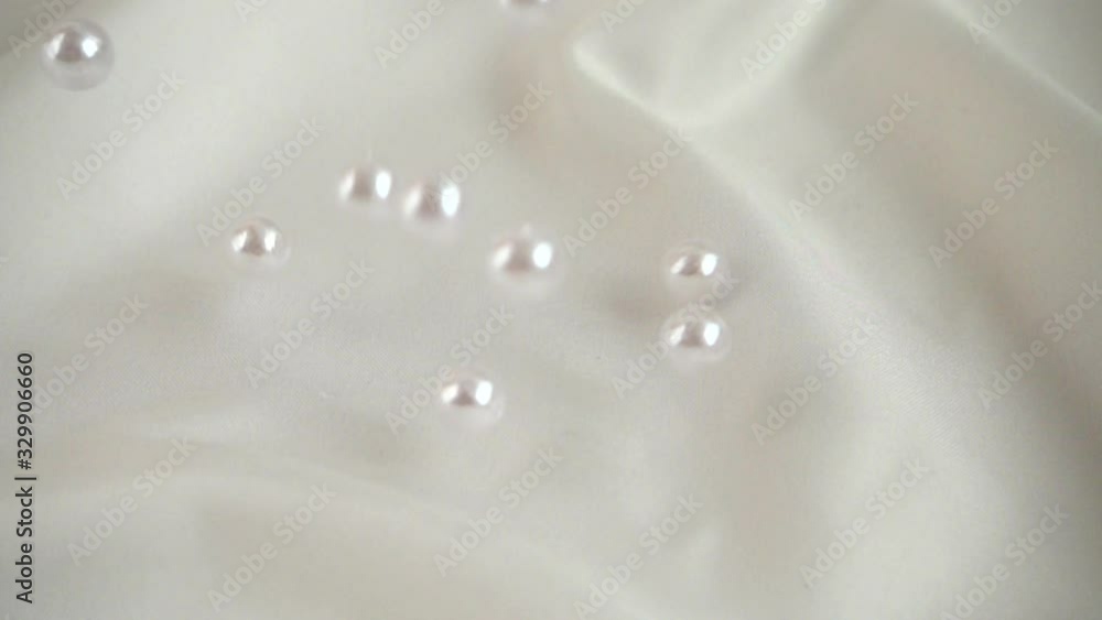 Pearls fall on silk. Slow motion. Pearls fall on silk. Slow motion.