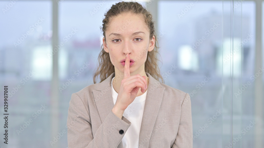 Portrait of Young Businesswoman putting Finger on Lips Portrait of Young Businesswoman putting Finger on Lips