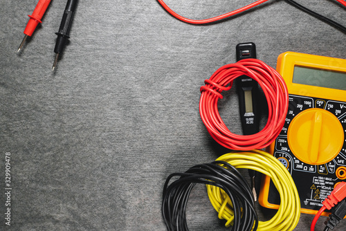 Multimeter and cables on gray flat lay background with copy space.