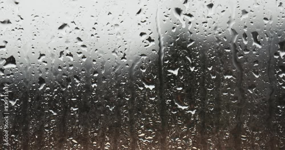 Raindrops running down the window glass surface Raindrops running down the window glass surface