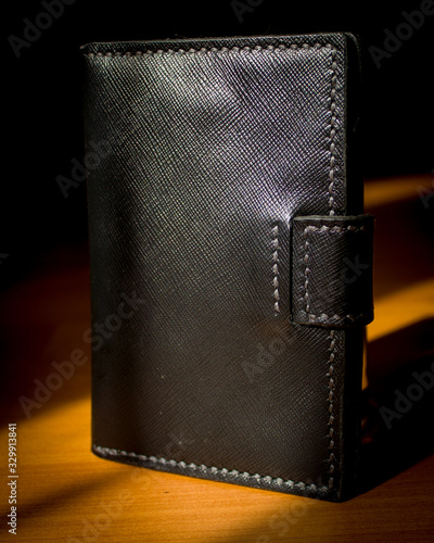 handmade black leather wallet located on a wooden board