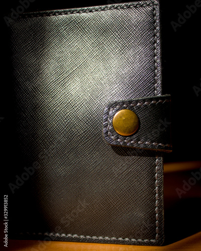 handmade black leather wallet located on a wooden board