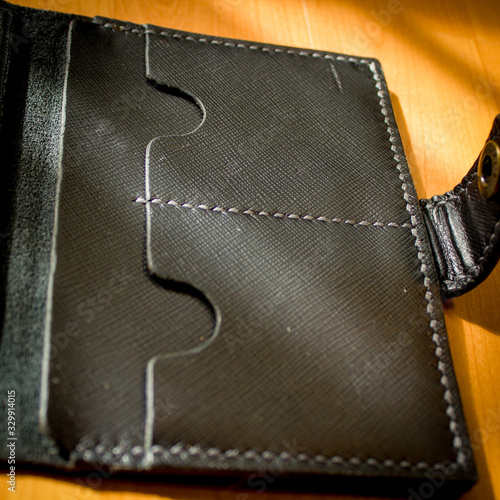 handmade black leather wallet located on a wooden board