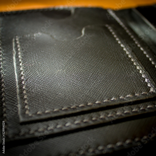 handmade black leather wallet located on a wooden board