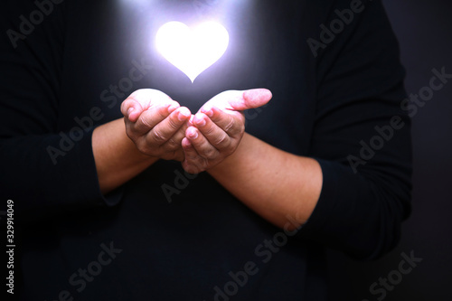 Photo hand with shining heart shape holy spiritual bokeh light effect, Love for all co