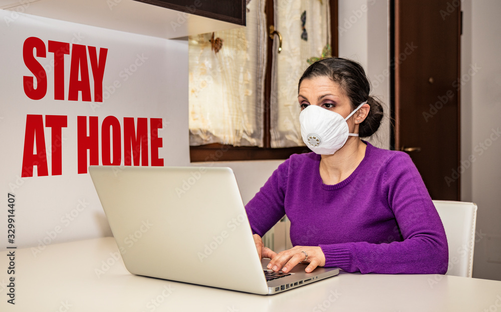 Coronavirus, Covid-19. Stay at home. Quarantine. Protection mask. A beautiful Caucasian woman forced to stay home to prevent virus infection, works on the laptop. Smart Working. Coronavirus, Covid-19. Stay at home. Quarantine. Protection mask. A beautiful Caucasian woman forced to stay home to prevent virus infection, works on the laptop. Smart Working.